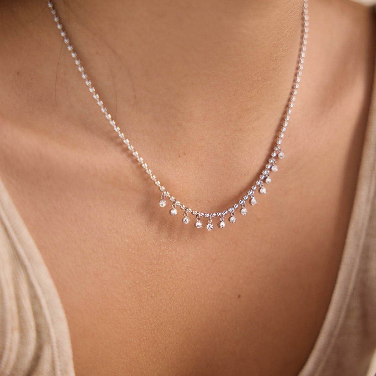 Steel color clear-drop fringe necklace worn close-up