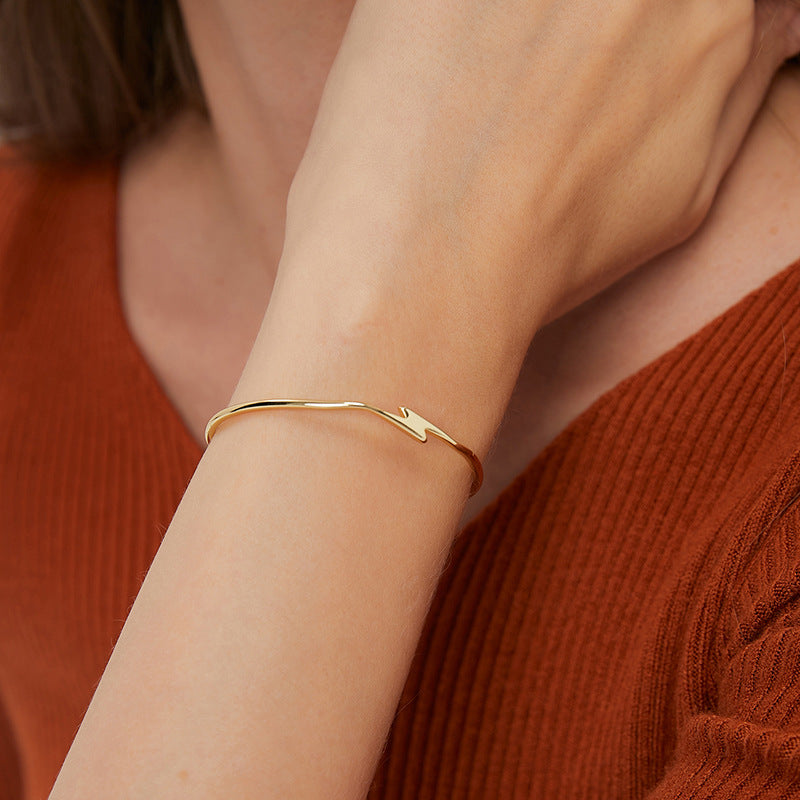 model wearing a slim gold plated lightning bolt bangle