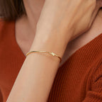 model wearing a slim gold plated lightning bolt bangle