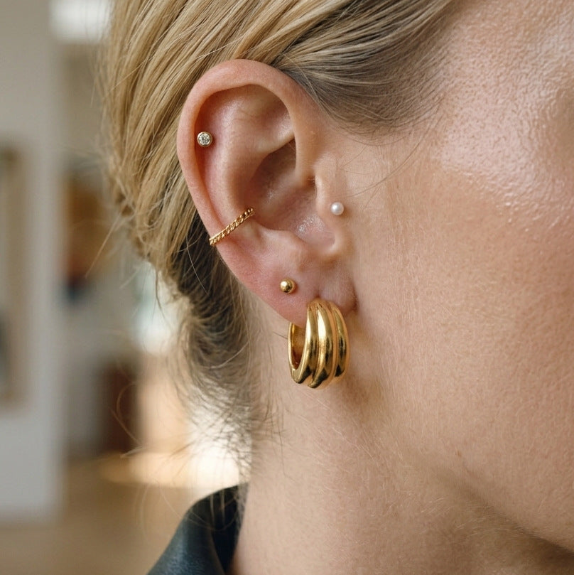 gold plated stainless steel triple-ridge hoop earrings worn on ear
