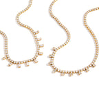 Gold-tone tennis necklaces on white