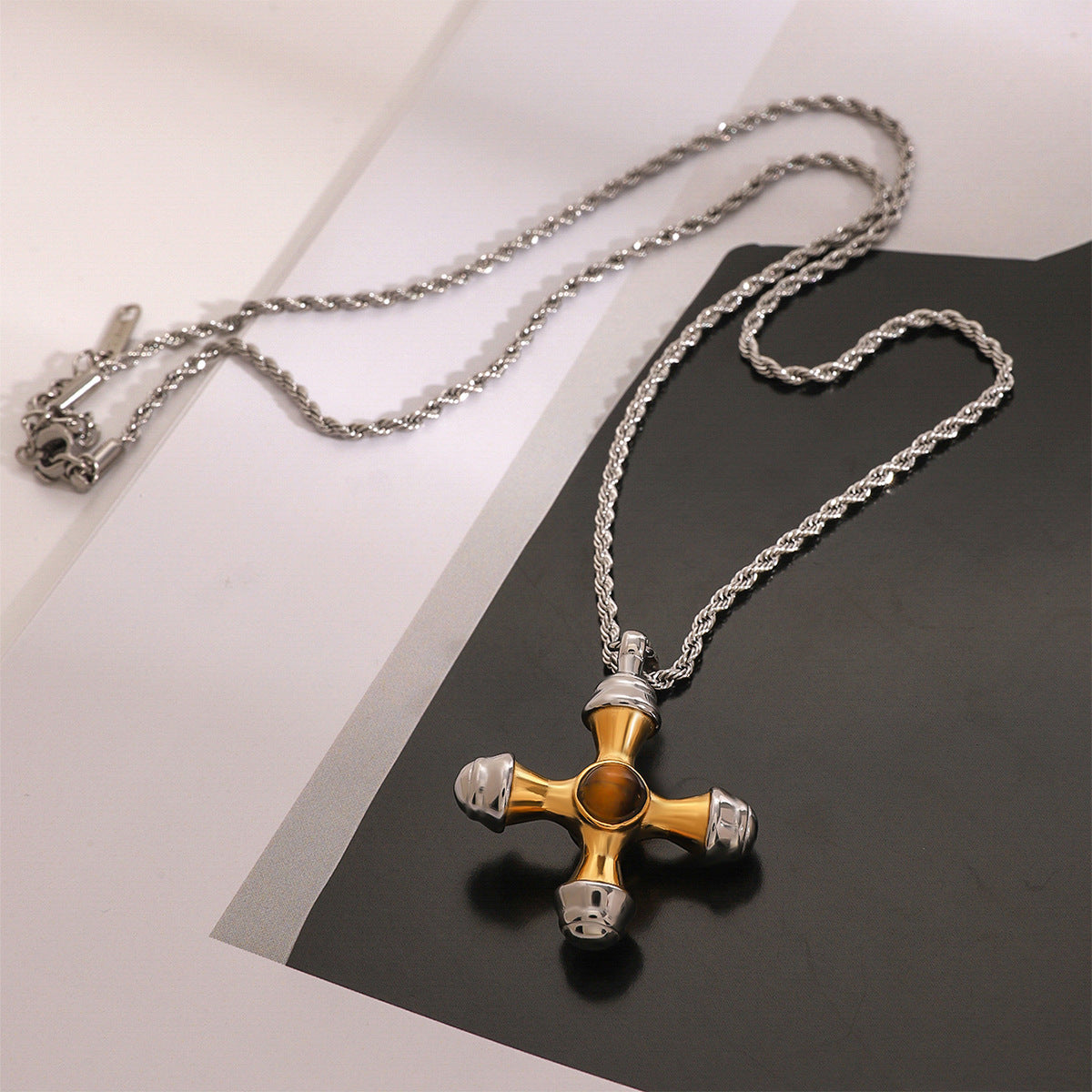 Two-tone rounded cross pendant on a silver-colored rope chain