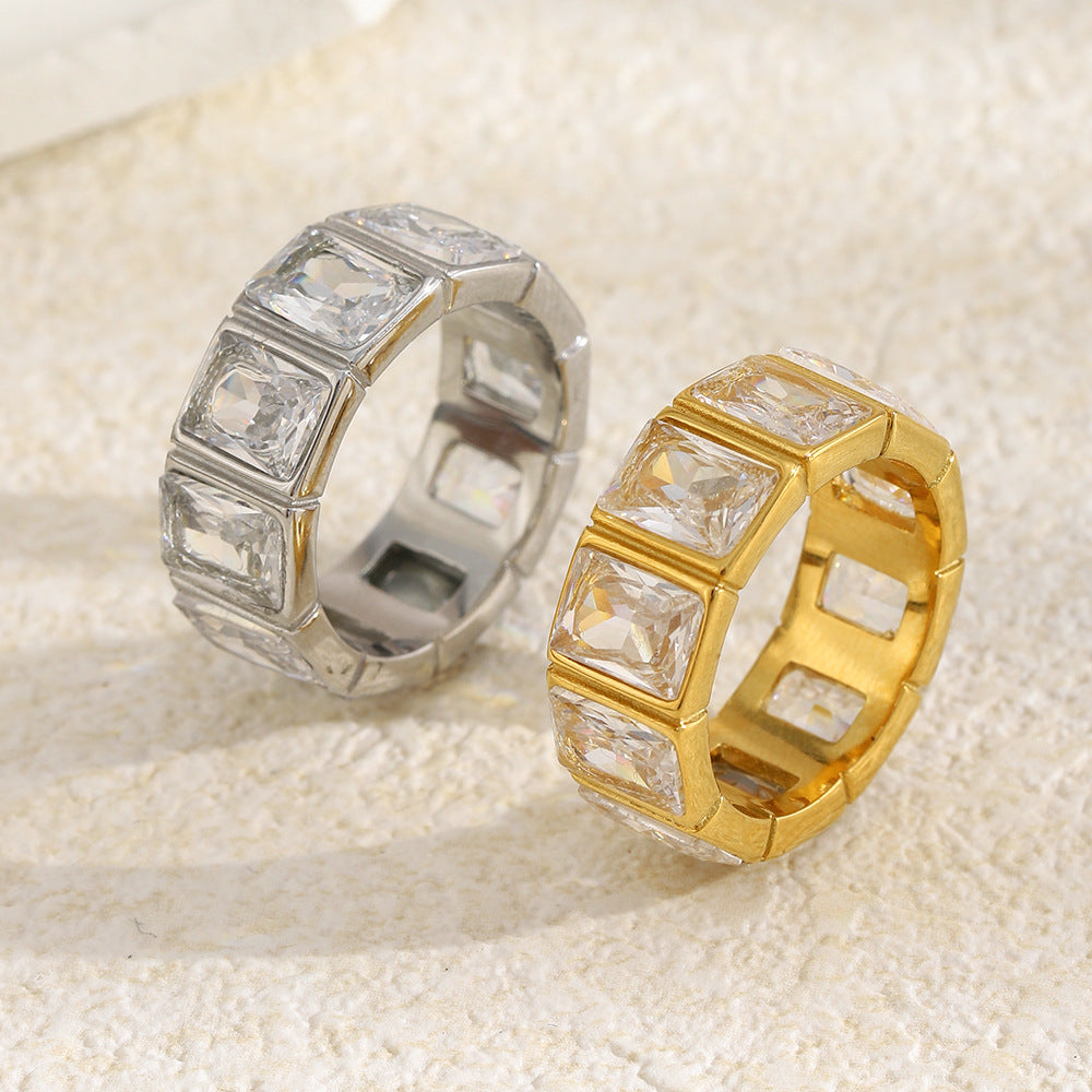 pair of stainless steel clear stone eternity bands on a neutral surface
