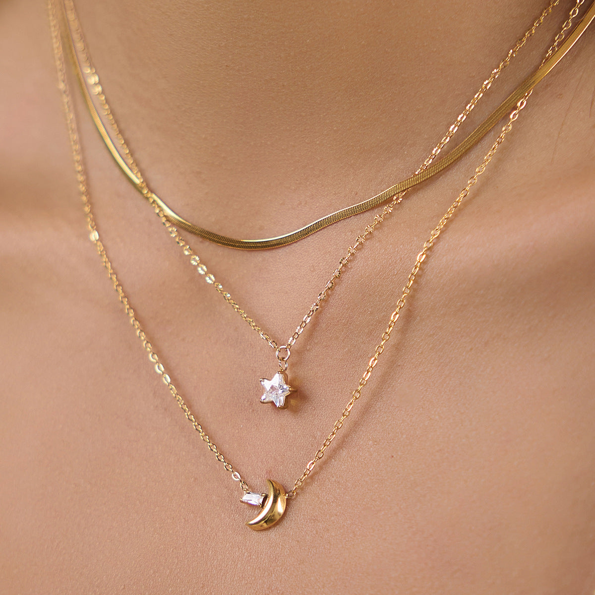 Clear star and gold tone crescent pendants worn together