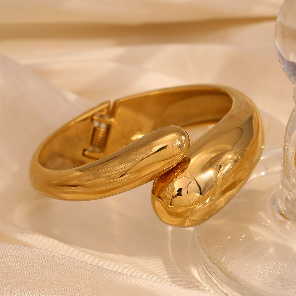 side view of gold plated hinged bangle with overlapping snake-head ends