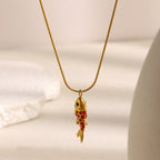 Vertical fish pendant hanging from a fine chain