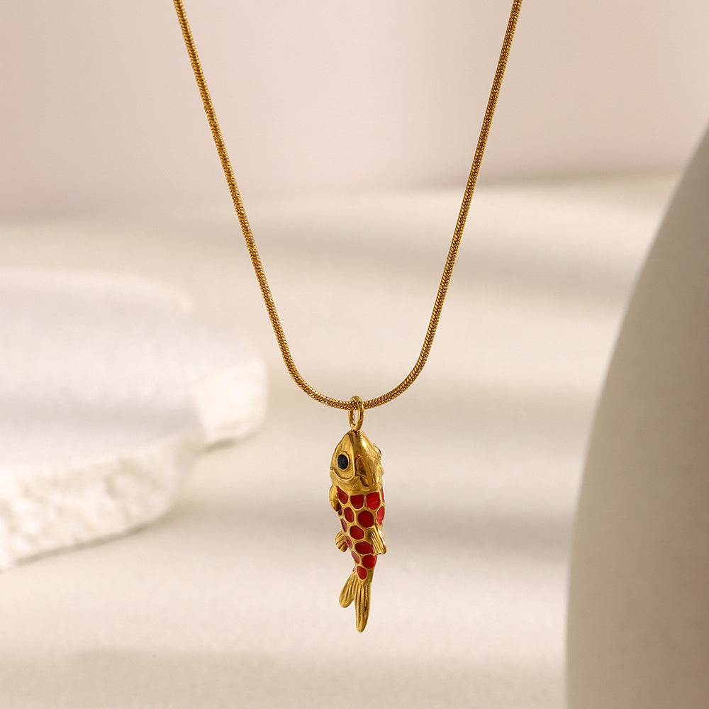 Vertical fish pendant hanging from a fine chain