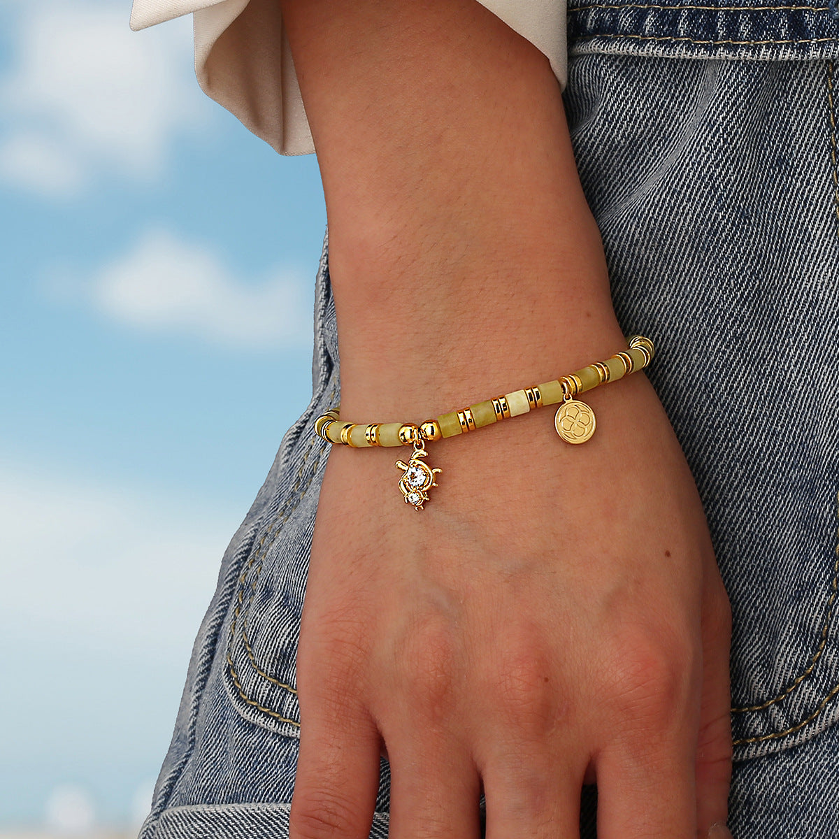 model wearing the sea turtle pale yellow bead bracelet outdoors