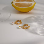 Twisted hoops with round clear drops beside a lemon
