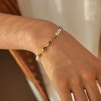 gold plated stainless steel white bead bracelet worn across the wrist