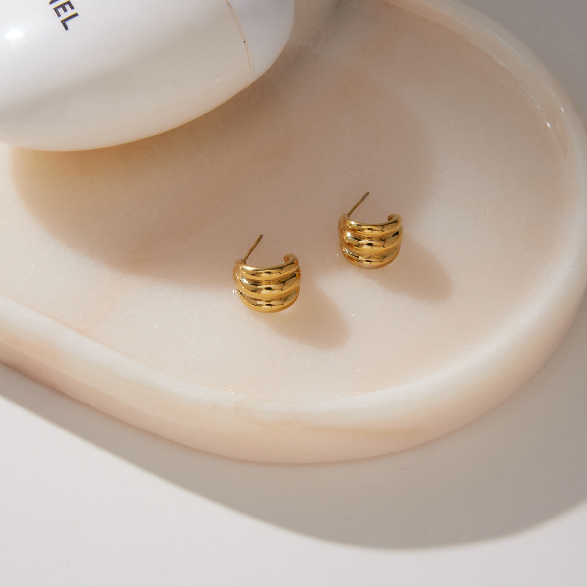 Triple ridge earrings showing posts on a white tray