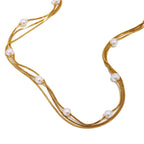 Gold plated triple-strand faux pearl necklace detail