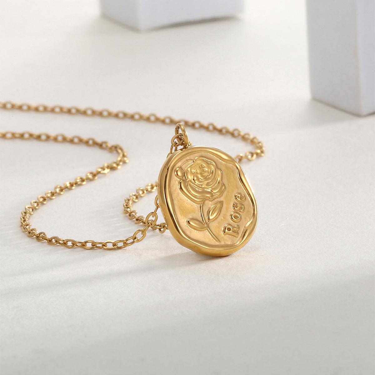 irregular rose medallion pendant displayed on a pale surface
