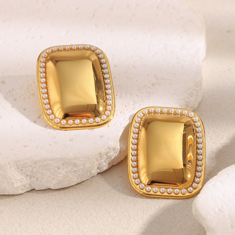 statement rectangular pearl-border earrings displayed on white blocks