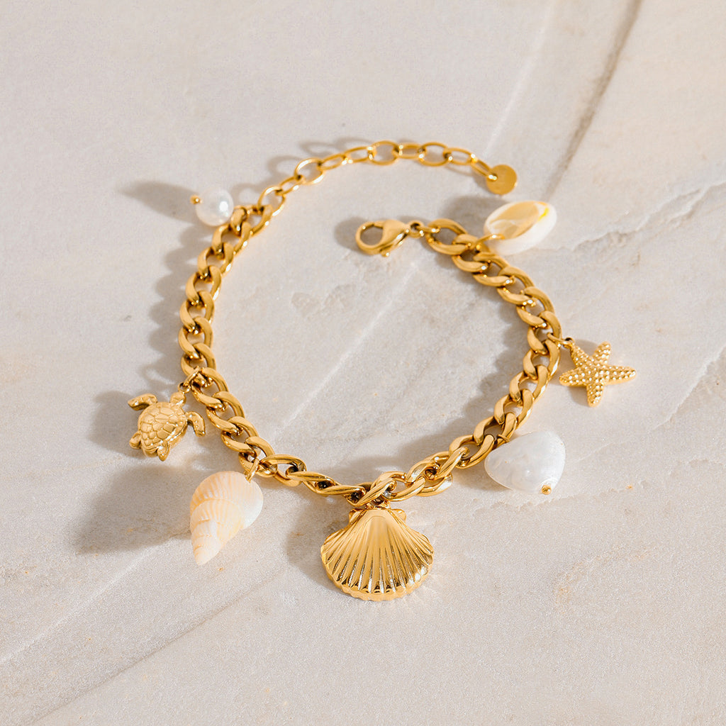 Scallop and turtle charms on the stainless steel curb bracelet