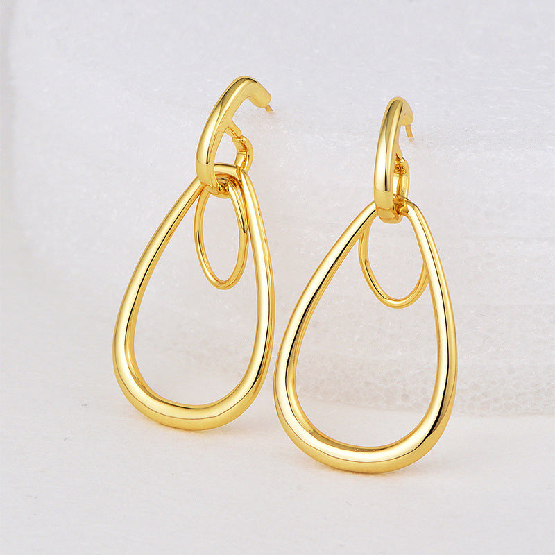 gold plated double teardrop drop earrings on a white display