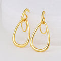 gold plated double teardrop drop earrings on a white display