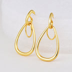gold plated double teardrop drop earrings on a white display