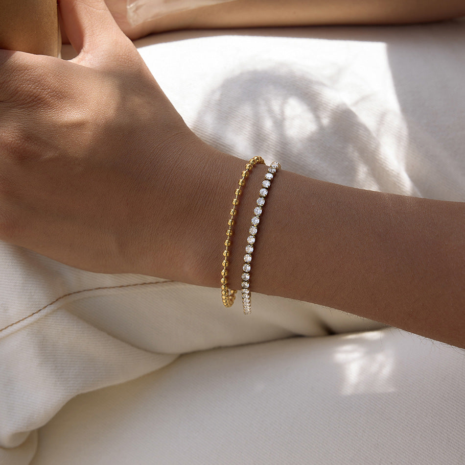 Double-row bead and clear stone bracelet worn on a wrist