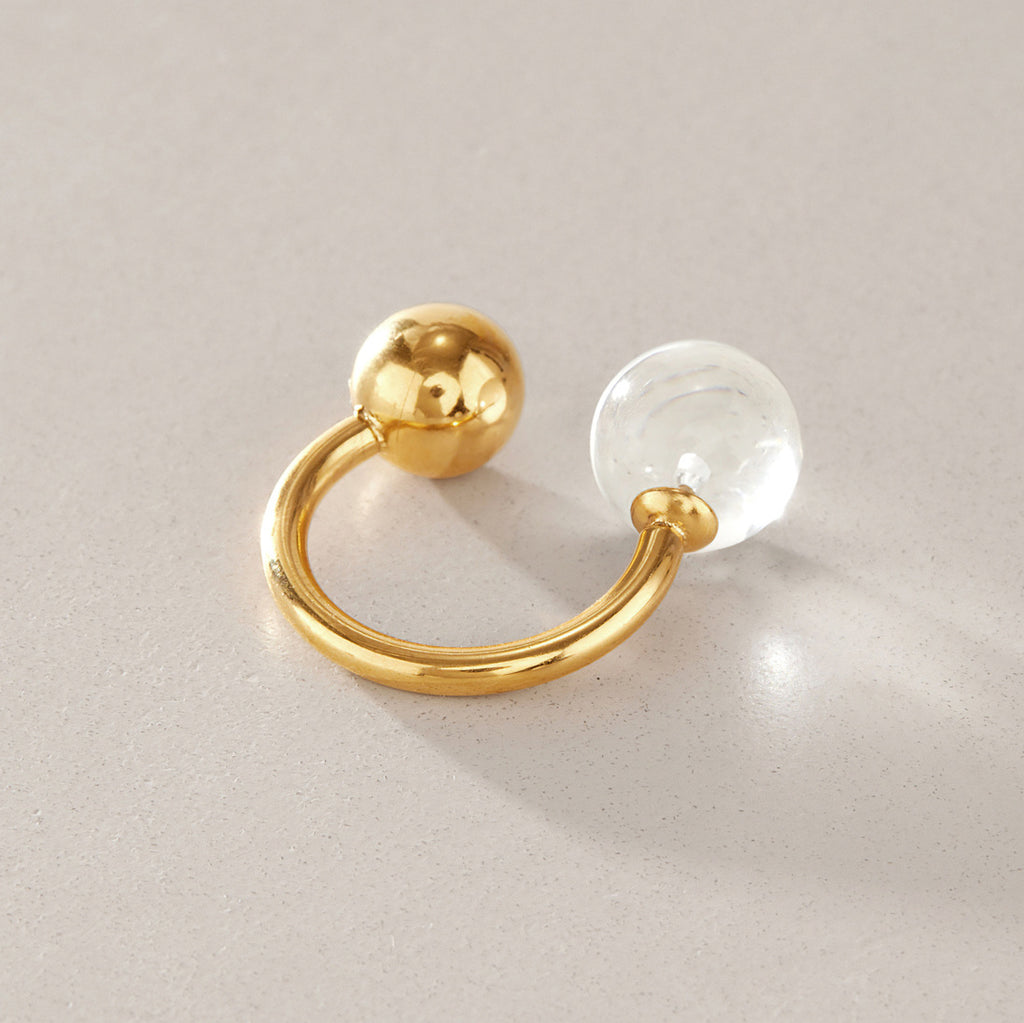 Open ring with transparent sphere and polished metal ball