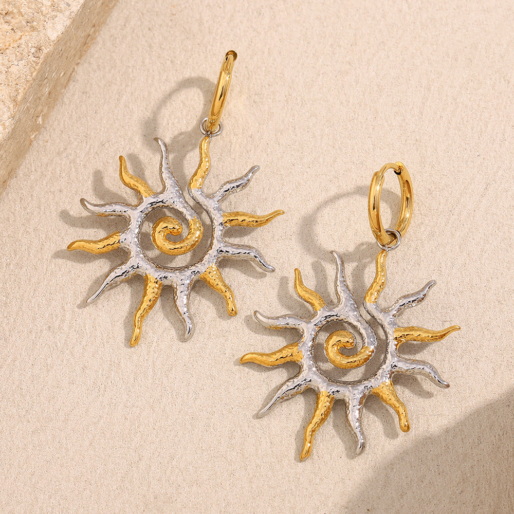 two-tone stainless steel sunburst drop earrings on cream stone