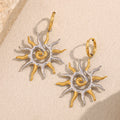 two-tone stainless steel sunburst drop earrings on cream stone
