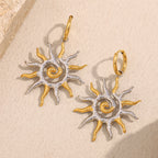two-tone stainless steel sunburst drop earrings on cream stone