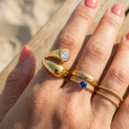 Sculptural bypass ring worn beside other gold tone rings