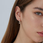 vertical pearl zirconia ear climber worn along the earlobe