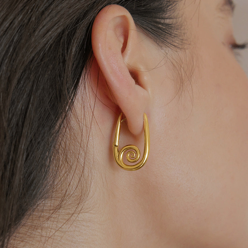Spiral elongated hoop earring worn close-up