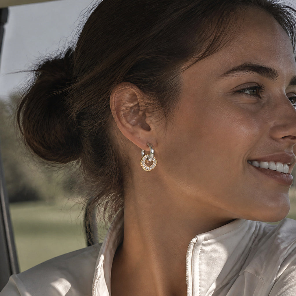 Mixed-tone rhinestone disc earring worn on an ear