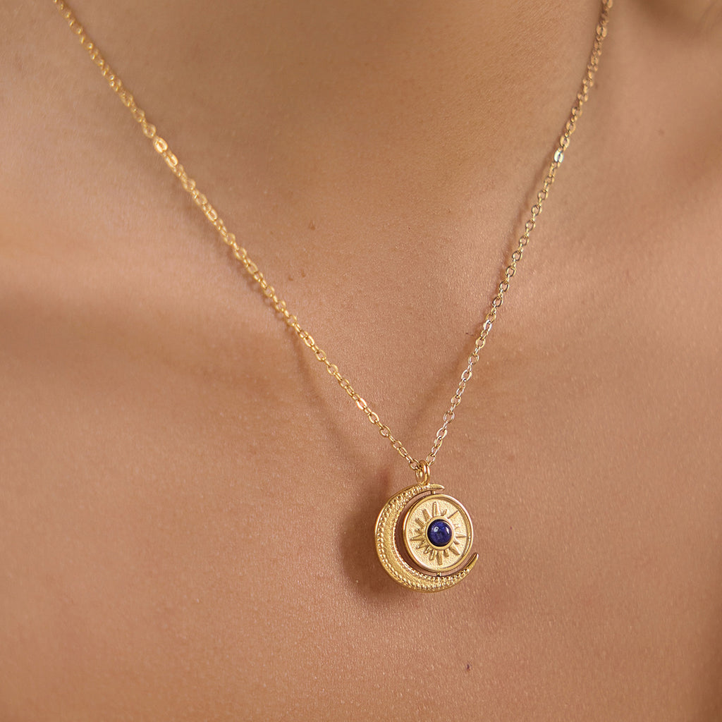 Sun and crescent pendant with blue center worn at neckline