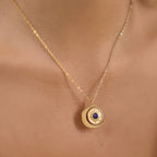 Sun and crescent pendant with blue center worn at neckline