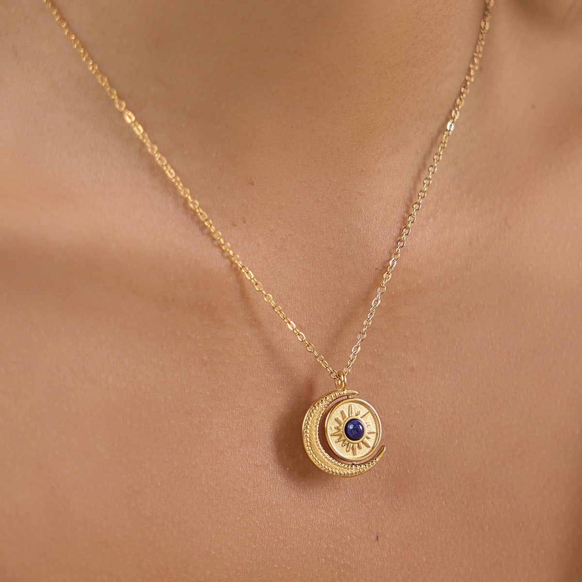 Sun and crescent pendant with blue center worn at neckline