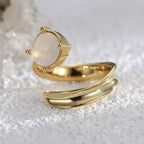 side view of sculptural crescent cabochon ring on pale stone
