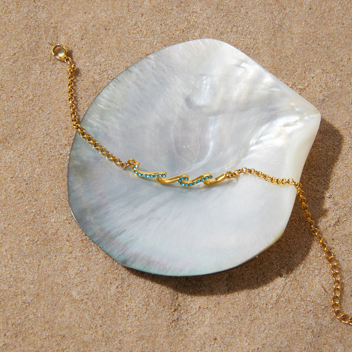 Fine gold plated bracelet with blue wave details on shell