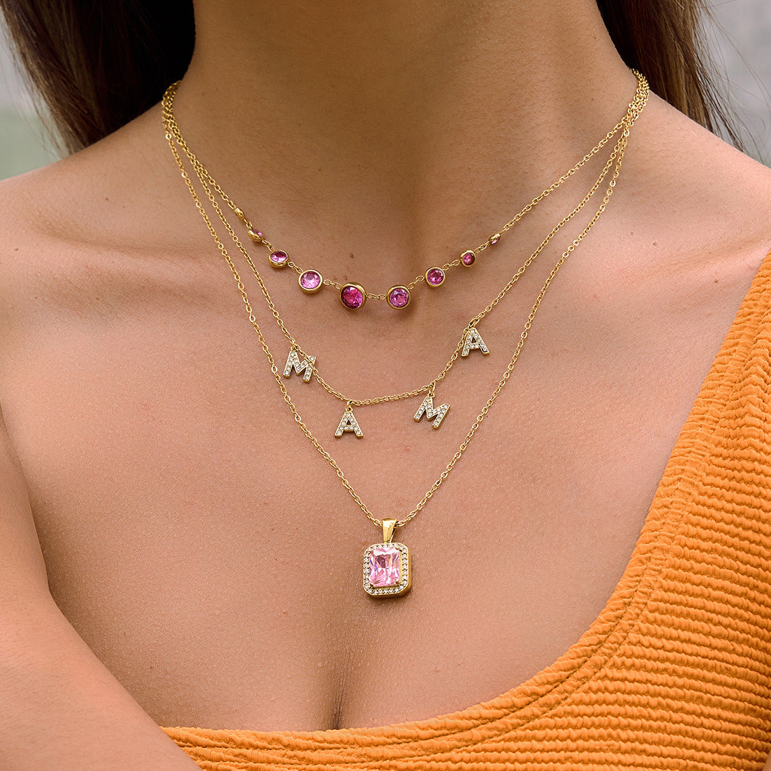 Pink bezel necklace worn with layered pendants