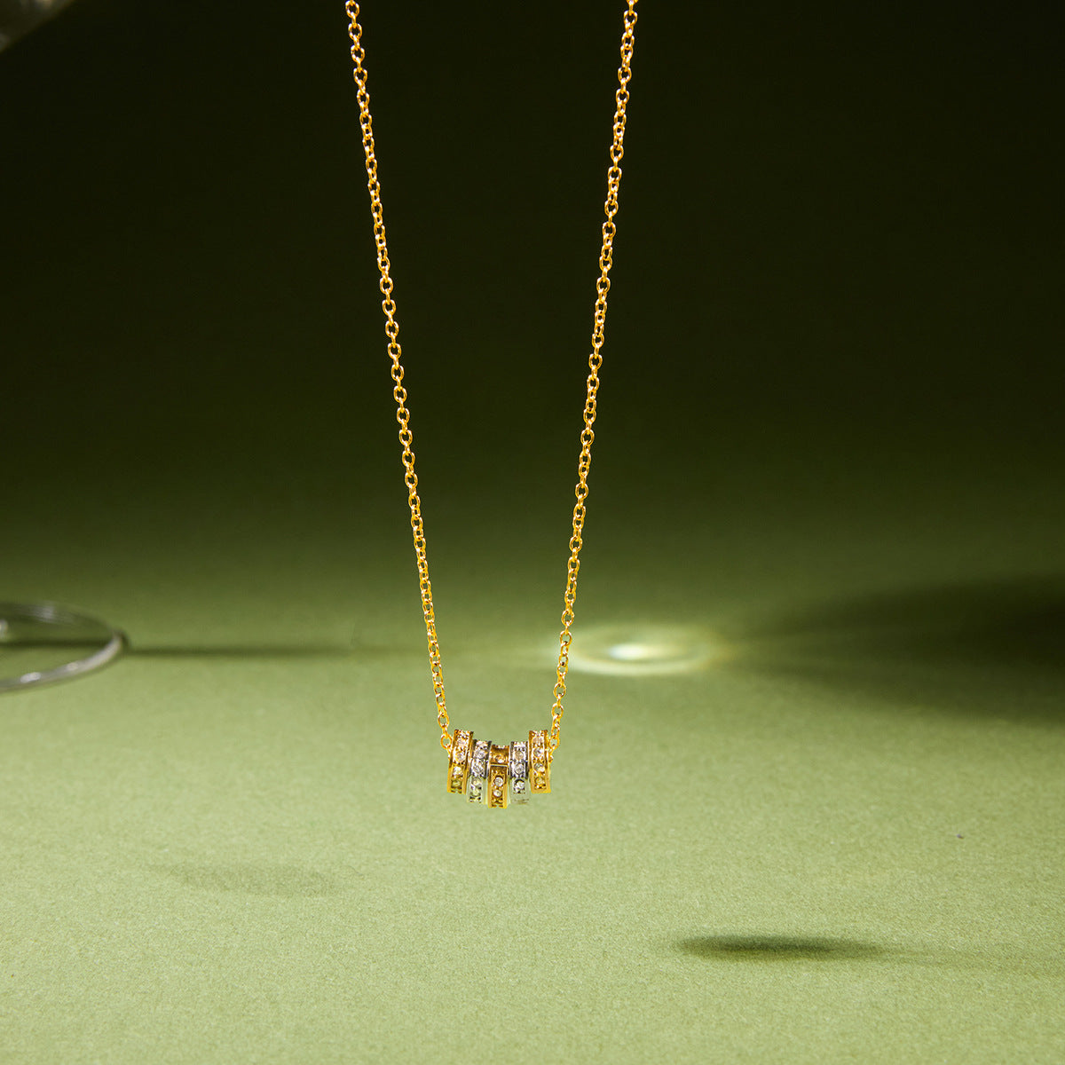 Gold-tone necklace with multicolor cube accents on green