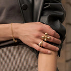 Gold plated four-petal flower ring worn on a hand