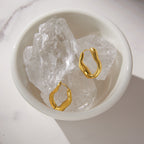 Pair of wavy hoops displayed on clear display stones