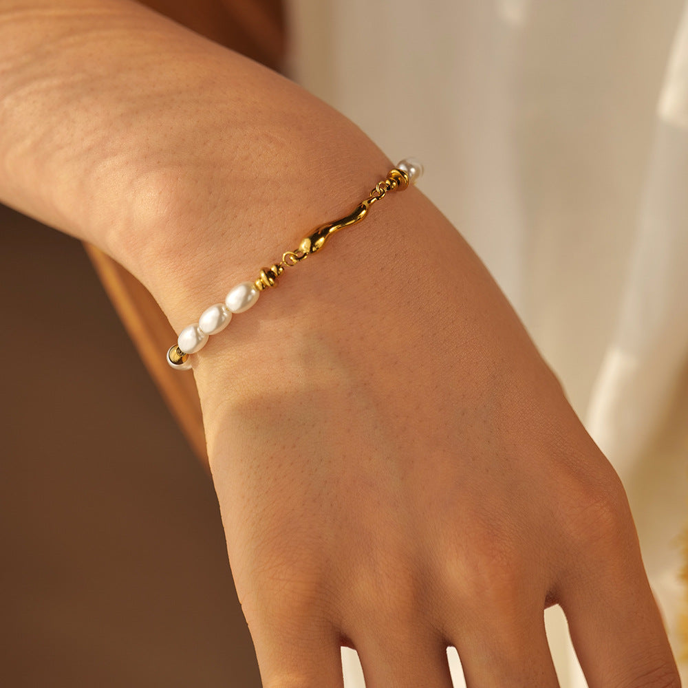 white oval bead bracelet with twisted gold plated spacers on the wrist