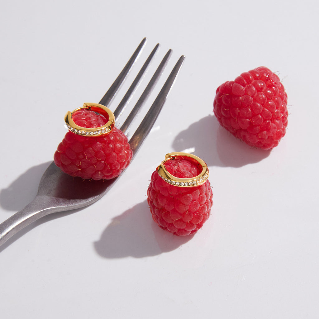 Gold finish stone-set hoops displayed on raspberries