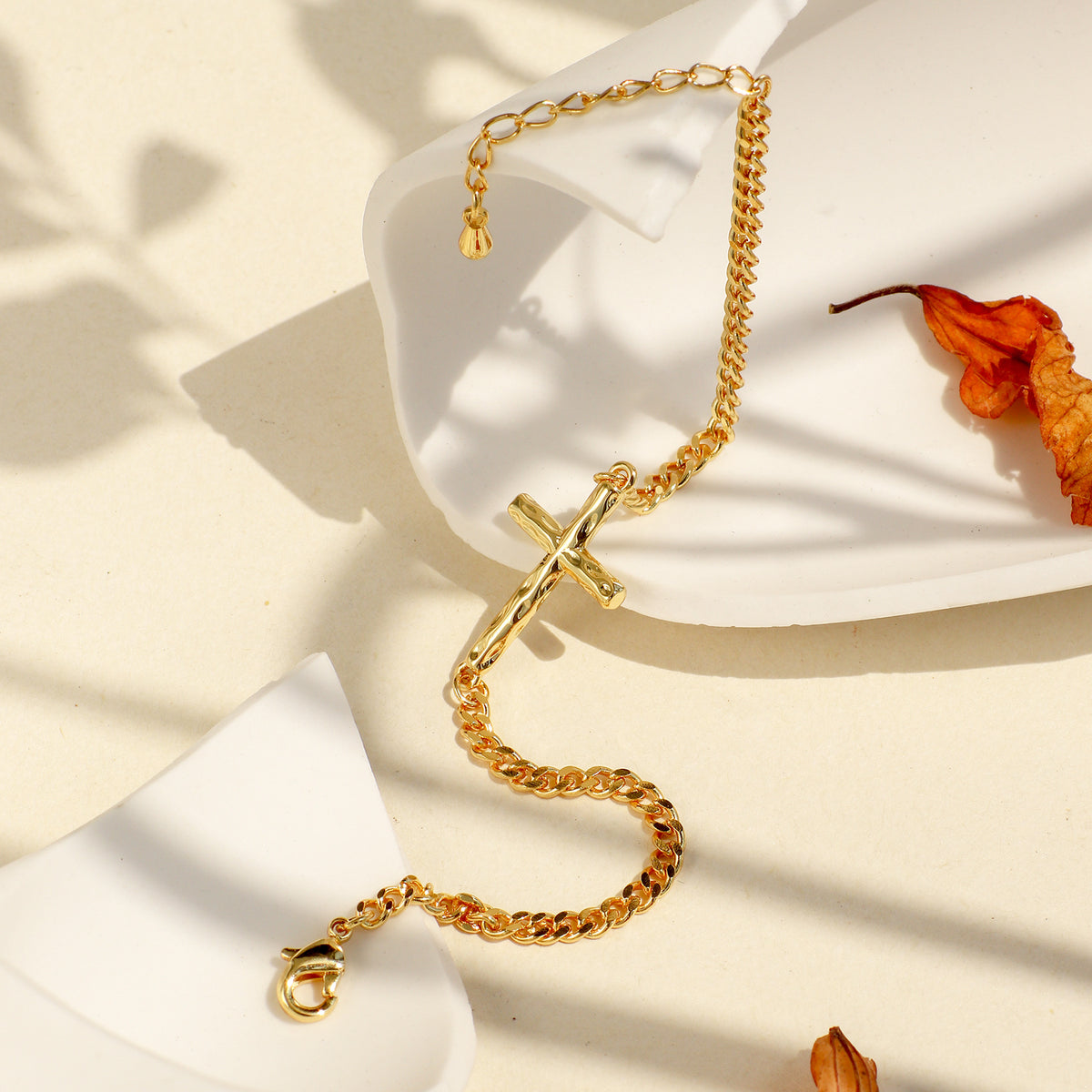 gold plated cross chain bracelet styled on a display stand
