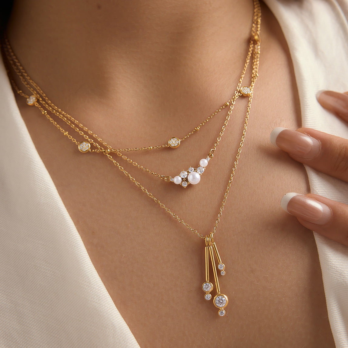 Cluster and bar-drop necklaces worn in layers