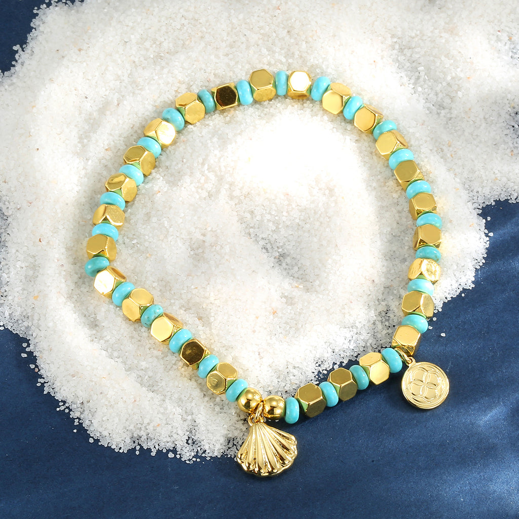 shell charm turquoise-color bead bracelet styled on white granules