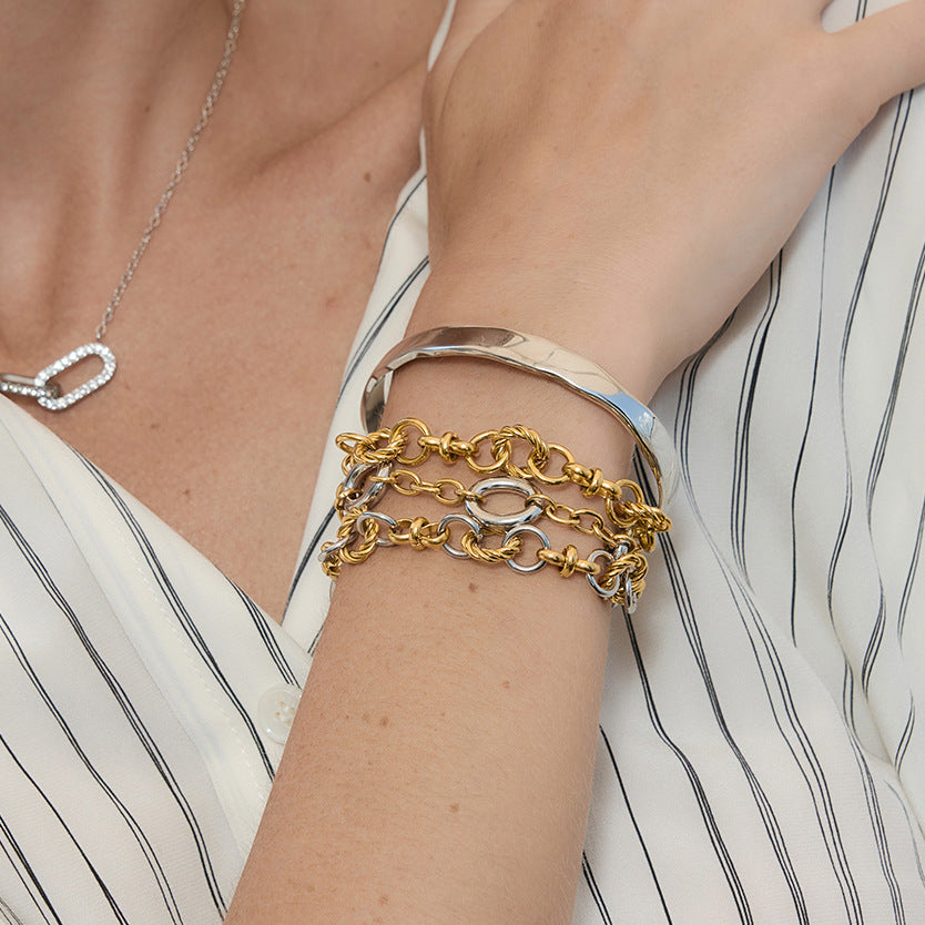 Linked bracelet and wavy cuff shown on wrist