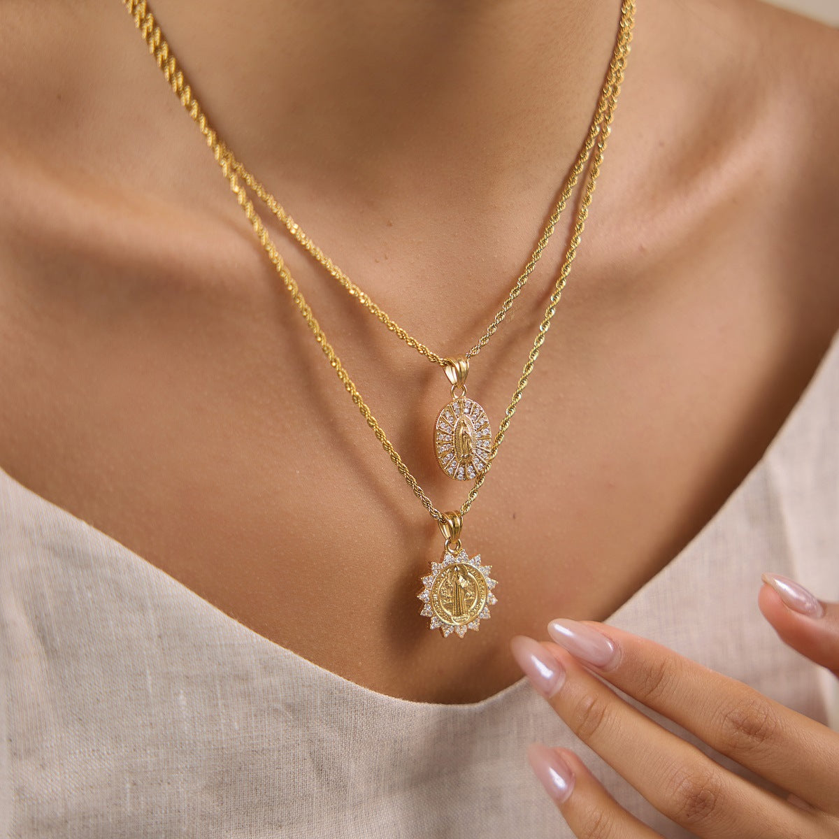Oval and sunburst portrait medallion necklaces layered on model