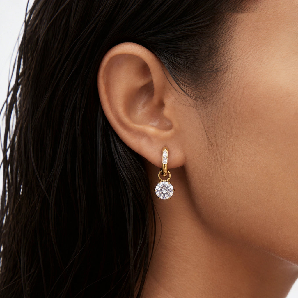 Round zirconia hoop earring worn on an ear