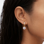 Round zirconia hoop earring worn on an ear