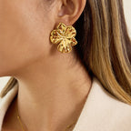 Oversized gold plated flower stud worn beside the face